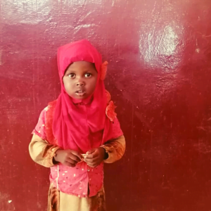 Kaksivuotias Caisha tyttö katsoo suoraan kameraan.